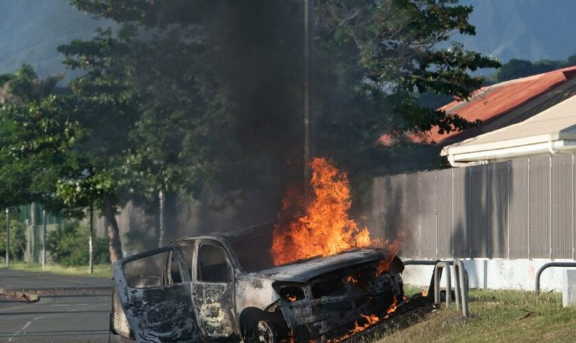 Une voiture en feu aux alentours de Nouméa, en Nouvelle-Calédonie, le 16 mai 2024