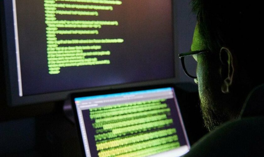 Un homme en train de hacker un système informatique (illustration)