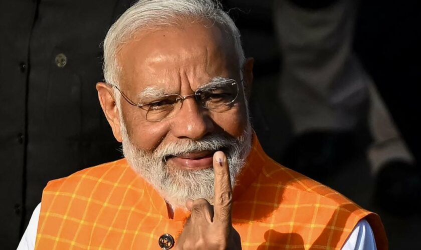 Le premier ministre indien Narendra Modi montre son doigt marqué d'encre, preuve qu'il a voté aux élections législatives, le 7 mai 2024, à Ahmedabad (Inde).