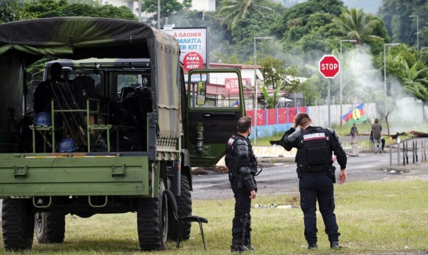 Des gendarmes français montent la garde près d'indépendantistes à l'entrée du quartier de Rivière-Salée, à Nouméa, en Nouvelle-Calédonie, territoire français du Pacifique, le 29 mai 2024. Des émeutes déclenchées par un projet de réforme constitutionnelle ont éclaté le 13 mai. La France a levé l'état d'urgence sur le territoire après deux semaines de troubles qui ont fait sept morts et des centaines de blessés (Photo Theo Rouby / AFP).