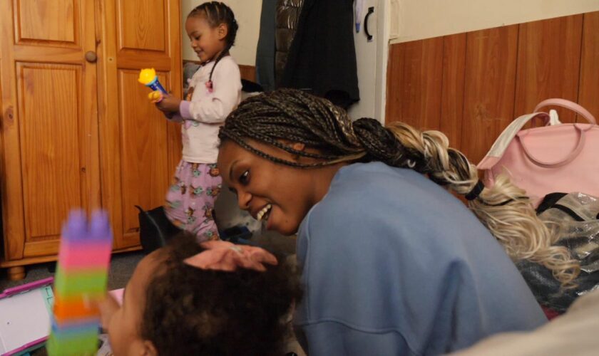 Rose plays with her children in their cramped accommodation