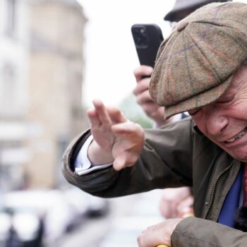 Farage takes cover on open-top bus as man throws objects at him