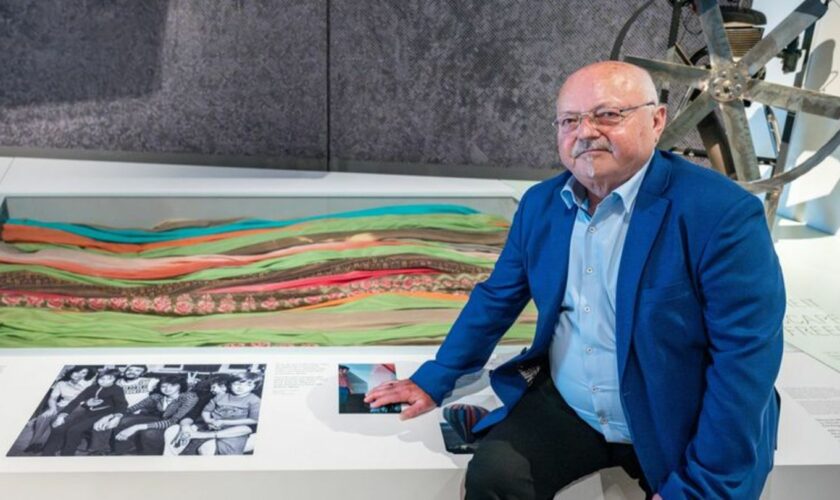 Günter Wetzel sitzt im Haus der Bayerischen Geschichte an einer Vitrine. Foto: Armin Weigel/dpa