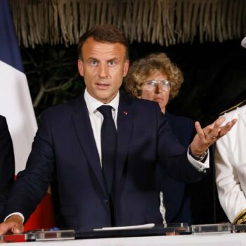 Le président Emmanuel Macron (c) prononce un discours entouré du ministre de l'Intérieur Gérald Darmanin (g) et du haut-commissaire de la Nouvelle-Calédonie Louis Le Franc, le 24 mai 2024 à Nouméa