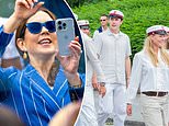 Queen Mary of Denmark takes photos of her son Crown Prince Christian as he sprays champagne from a party bus to celebrate his high school graduation