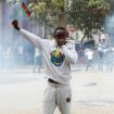 A man holds up a flag of Kenya as police use teargas to disperse protesters during a demonstration over police killings of people protesting against the imposition of tax hikes by the government in Nairobi, Kenya, July 2, 2024. REUTERS/Monicah Mwangi