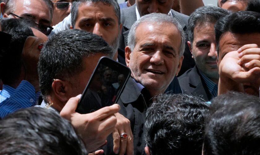 Reformist candidate for the Iran's presidential election Masoud Pezeshkian is greeted by his supporters as he arrives to vote at a polling station in Shahr-e-Qods near Tehran, Iran, Friday, July 5, 2024. Iranians are voting in a runoff election to replace the late President Ebrahim Raisi, who was killed in a May helicopter crash in the country...s northwest along with the foreign minister and several other officials. (AP Photo/Vahid Salemi)