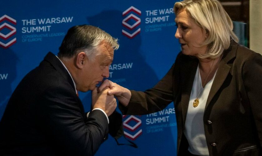 Le chef du parti d'extrême droite français Rassemblement National (RN) et candidat aux élections présidentielles françaises Marine Le Pen (R) et le Premier ministre hongrois Viktor Orban (L) posent avant la réunion des dirigeants des partis européens conservateurs et de droite "Le Sommet de Varsovie, à Varsovie, en Pologne, le 4 décembre 2021. (Photo de Wojtek RADWANSKI / AFP)