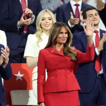 Former first lady Melania Trump waves as she is flanked by vice presidential nominee Senator J.D. Vance (R-OH) and Donald Trump Jr., as Republican presidential nominee and former U.S. President Donald Trump speaks on Day 4 of the Republican National Convention (RNC), at the Fiserv Forum in Milwaukee, Wisconsin, U.S., July 18, 2024. REUTERS/Andrew Kelly