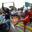 Un manifestant donne un coup de pied dans une bannière de campagne du président vénézuélien Nicolas Maduro lors d'une manifestation à Valencia (Etat de Carabobo), au Venezuela, le 29 juillet 2024