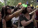 Angry mob of 'anti-tourism' protesters use water pistols to drench foreigners visitors at restaurants in Barcelona - as thousands march on Spanish capital and call for a tourists to 'go home'