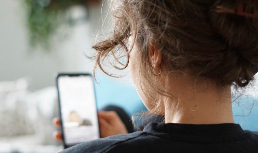 ILLUSTRATION - 28 September 2023, Berlin: A woman lies on a sofa and watches a video on the social media platform Instagram on her cell phone. (to dpa "#therapy: Pseudopsychology in social media and its consequences") Photo by: Weronika Peneshko/picture-alliance/dpa/AP Images