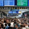 Des passagers se rassemblent autour des tableaux des départs et des arrivées à la gare Montparnasse à Paris, le 26 juillet 2024, après des actes de "sabotage" de grande ampleur.