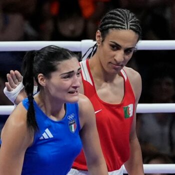 Algeria's Imane Khelif, red, next to Italy's Angela Carini, at the end of their women's 66kg preliminary boxing match at the 2024 Summer Olympics, Thursday, Aug. 1, 2024, in Paris, France. (AP Photo/John Locher)