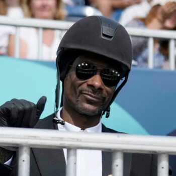 Snoop Dogg thumbs up as he watches the dressage team Grand Prix final at the 2024 Summer Olympics, Saturday, Aug. 3, 2024, in Versailles, France. (AP Photo/Mosa'ab Elshamy)