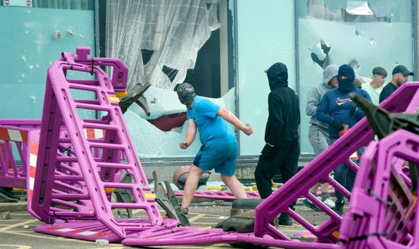 Windows are smashed as trouble flares during an anti-immigration protest outside the Holiday Inn Express in Rotherham, South Yorkshire. Picture date: Sunday August 4, 2024. PA Photo. See PA story POLICE Southport. Photo credit should read: Danny Lawson/PA Wire