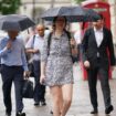 People walking in a rain shower on Whitehall in Westminster, London. Thunderstorms and hailstorms are set to sweep across parts of the UK on Thursday as temperatures reach up to 30C. Picture date: Thursday August 1, 2024.