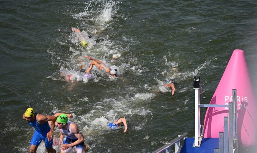 Athletes are swimming in the River Seine during the Men's Triathlon in Paris on July 31, 2024. The men's Olympic triathlon planned for the previous day has been postponed over concerns about water quality in the River Seine, where the swimming part of the race was scheduled to take place. ( The Yomiuri Shimbun via AP Images )