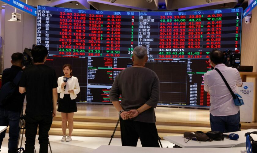 Media members report in front of screens showing trading data at the Taiwan Stock Exchange in Taipei, Taiwan August 6, 2024. REUTERS/Carlos Garcia Rawlins