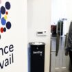 Une femme passe devant le logo de "France Travail", le nouvel opérateur du service public français de l'emploi à Paris le 3 janvier 2024.