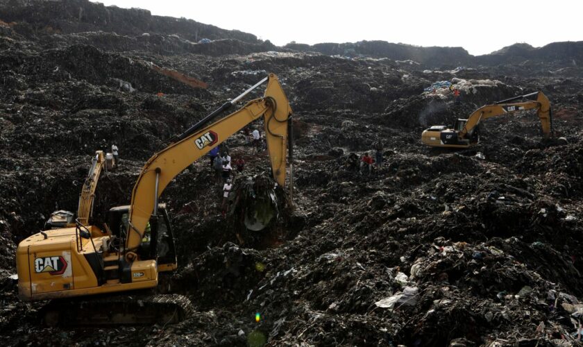 Onlookers watch as workers search for survivors at the site of a collapsed landfill in Kampala, Uganda, Sunday, Aug. 11, 2024. (AP Photo/Hajarah Nalwadda)