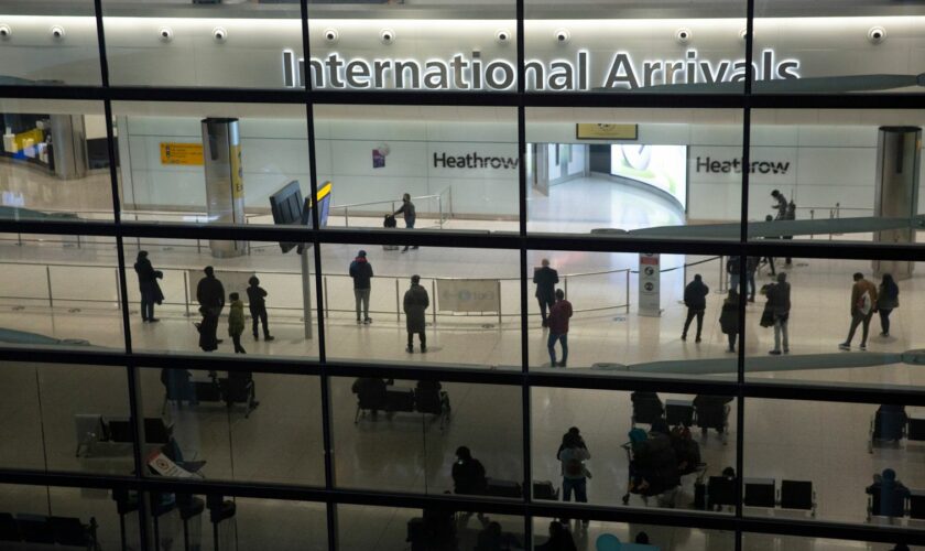 FILE - People in the arrivals area at Heathrow Airport in London, Jan. 26, 2021. The British government says it will grant extensions to several large U.K. airports unable to meet the June 1 deadline to fully install new scanning technology that would have allowed passengers to take two liters (70 ounces) of liquid in their hand luggage ... rather than the current paltry 100 milliliters (3.5 ounces). (AP Photo/Matt Dunham, File)