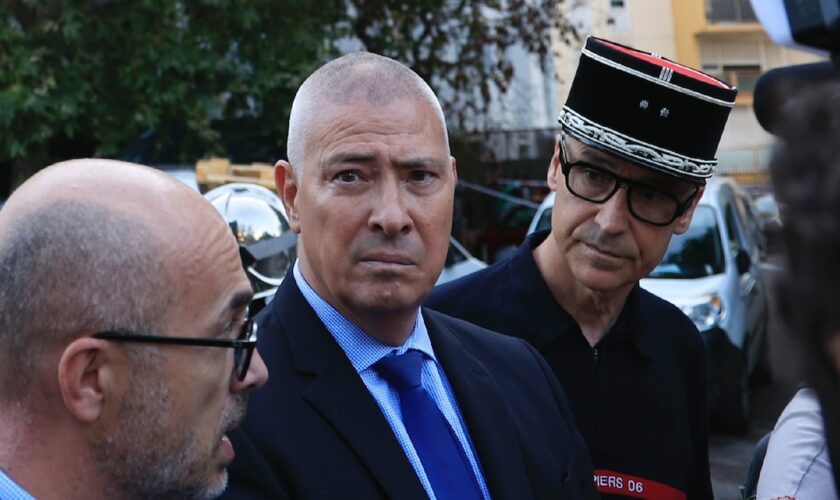 Le préfet des Alpes-Maritimes Hugues Moutouh (c) et le procureur Damien Martinelli (g) devant l'immeuble où un incendie s'est déclaré dans la nuit de mercredi à jeudi, faisant sept morts, le 18 juillet 2024 à Nice