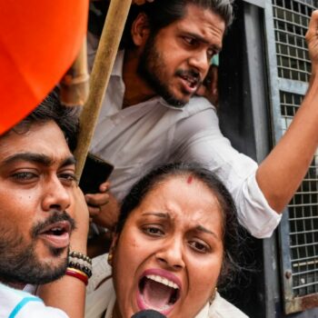 Detained supporters of India's ruling Bharatiya Janata Party (BJP) shout from a police vehicle during a protest against the rape and murder of a doctor. Pic: AP