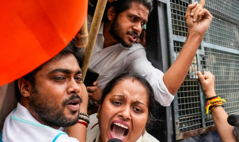 Detained supporters of India's ruling Bharatiya Janata Party (BJP) shout from a police vehicle during a protest against the rape and murder of a doctor. Pic: AP