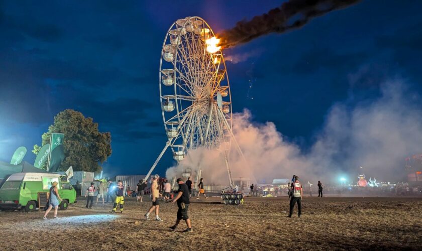 Festival-goers look on at the Ferris wheel fire. Pic: AP