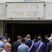 People stand by the entrance to the city's synagogue. Pic: Reuters