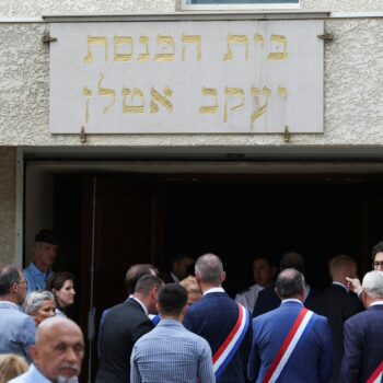 People stand by the entrance to the city's synagogue. Pic: Reuters