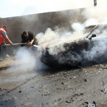 Des pompiers libanais éteignent le feu dans une voiture après une attaque israélienne à Saïda, dans le sud du Liban, le 21 août 2024, qui a tué un responsable de la branche armée du Fatah palestinien