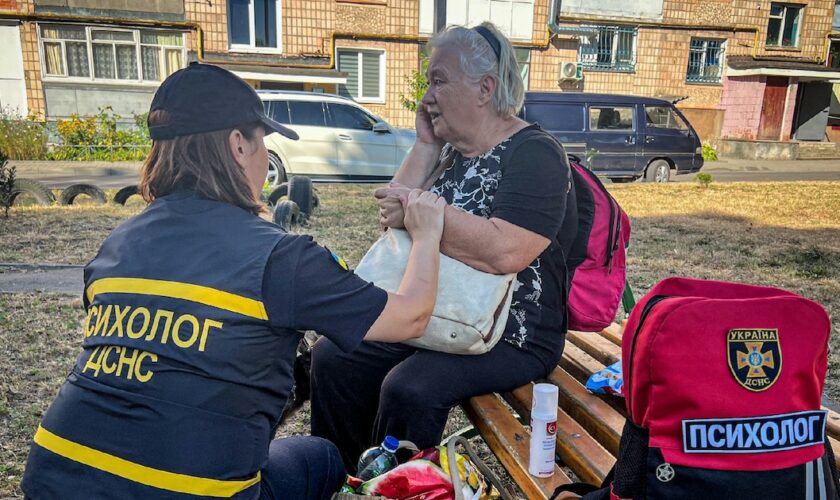 Photo diffusée par les services d'urgence ukrainiens, le 26 août 2024, d'une psychologue réconfortant une femme âgée après une frappe de missile russe à Loutsk, dans la région de Volhynie, en Ukraine