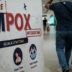 Un passager passe devant une bannière informant sur la variole du singe (MPOX) à l'aéroport international Soekarno-Hatta de Tangerang, le 26 août 2024.