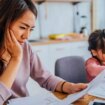 Young mother looking over finances next to daughter