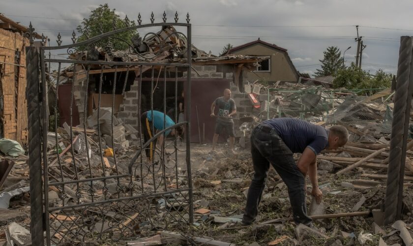 Des habitants dans les débris à proximité de maisons lourdement endommagées après un bombardement à Pokrovsk, dans la région de Donetsk, le 24 juin 2024 en Ukraine