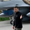 Le président ukrainien Volodymyr Zelensky (D) devant un chasseur F-16 lors d'une cérémonie dans un lieu tenu secret en Ukraine, le 4 août 2024