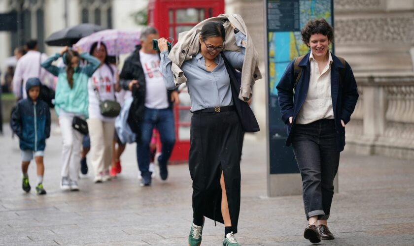 People walking in a rain shower on Whitehall in Westminster, London. Thunderstorms and hailstorms are set to sweep across parts of the UK on Thursday as temperatures reach up to 30C. Picture date: Thursday August 1, 2024. Pic: PA