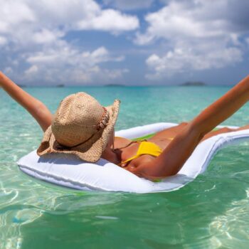 Eine Frau schwimmt auf einer Wasserhängematte