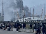 Film crew sparks mass panic as huge fire and 'five explosions' rock Thames yards from London's O2 arena leaving the area shrouded in thick smoke