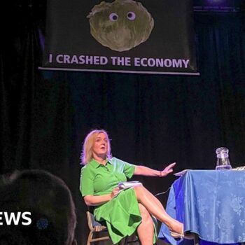 Liz Truss leaves stage as lettuce banner unfurls