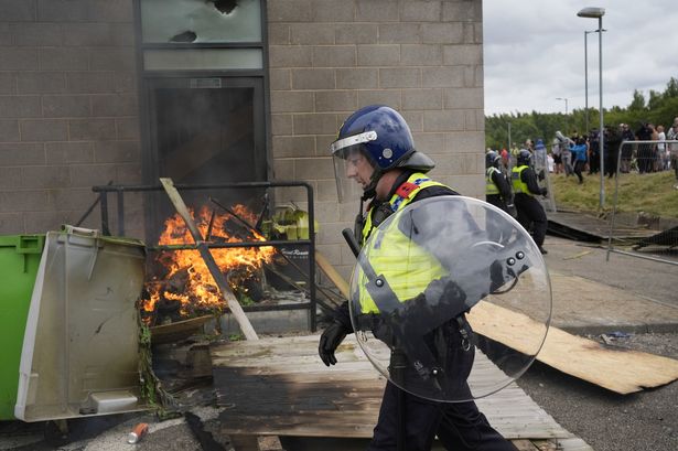 Moment masked man makes disturbing gesture to those inside Rotherham riot hotel