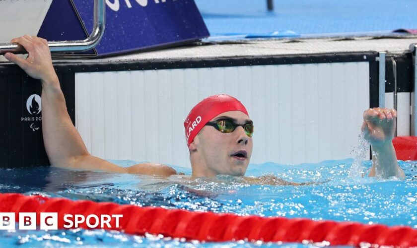 Great Britain's William Ellard raising his hand after he won his S14 butterfly heat this morning