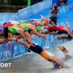 Triathletes dive into the River Seine at the start of the mixed team relay at the Paris 2024 Olympics