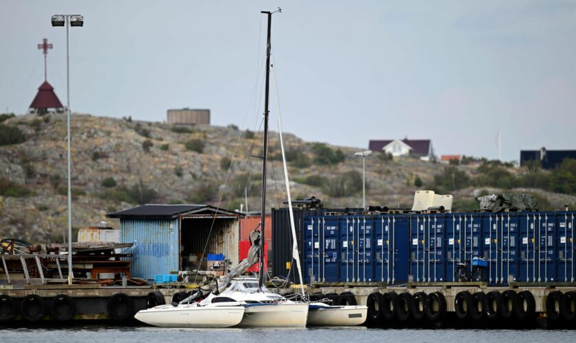 Ein Trimaran – ein Segelboot mit drei Rümpfen – ist in einer Ecke eines Hafens in Schweden festgemacht