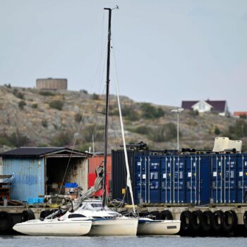 Ein Trimaran – ein Segelboot mit drei Rümpfen – ist in einer Ecke eines Hafens in Schweden festgemacht