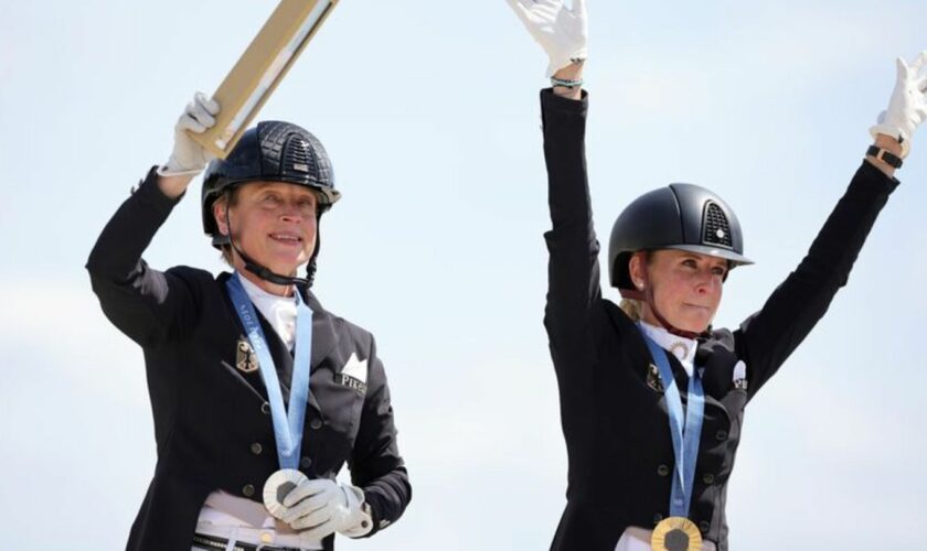 Jessica von Bredow-Werndl und Isabell Werth feiern ihre Medaillen. Foto: Rolf Vennenbernd/dpa