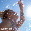 A woman pours water on herself from a plastic bottle as the sun beats down from a clear blue sky.