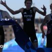 Alex Yee, Georgia Taylor-Brown, Beth Potter and Sam Dickinson pose with a Great Britain flag after winning bronze in the mixed relay triathlon at the Paris 2024 Olympics